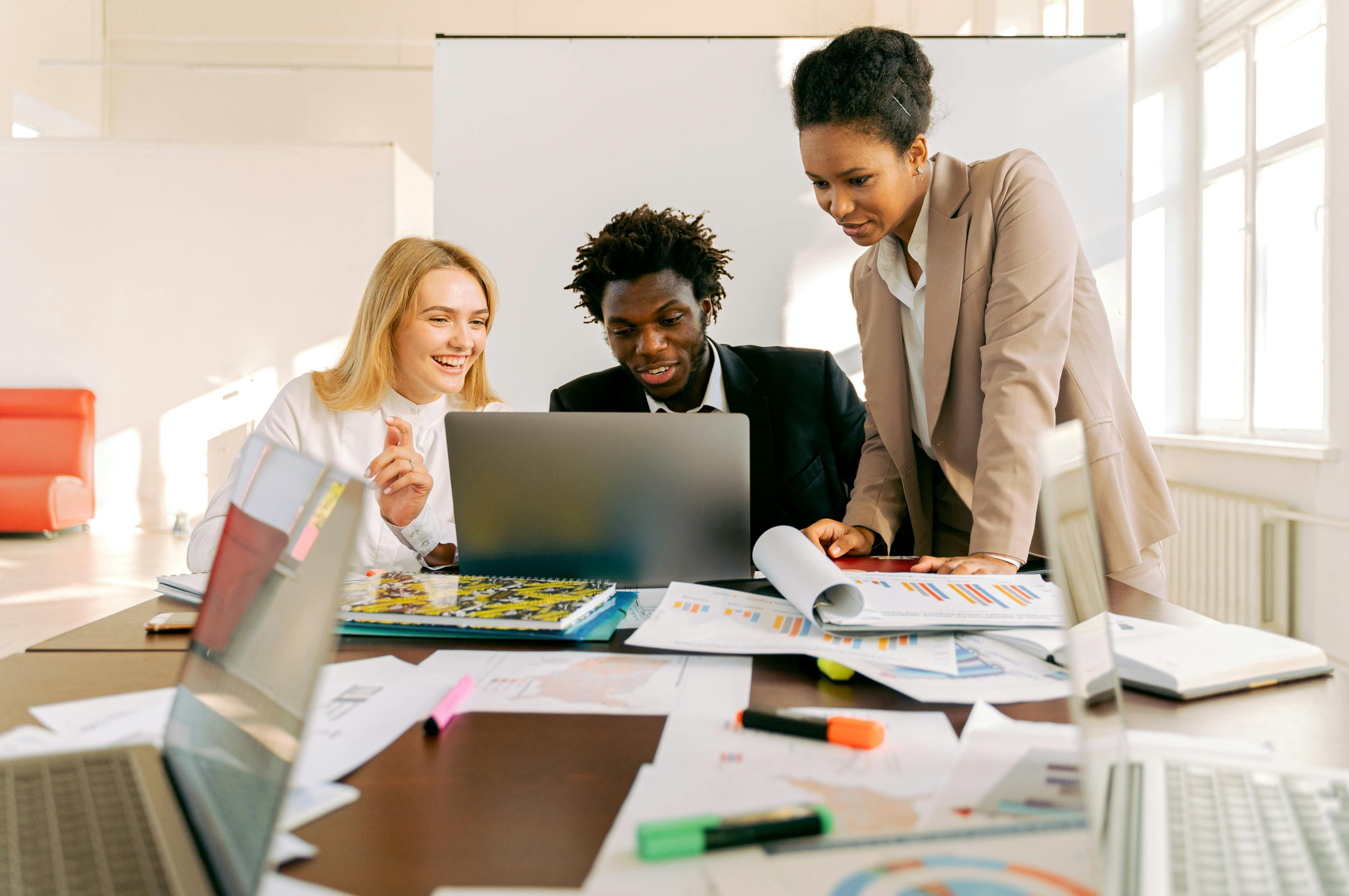 Diverse strategy team reviewing plans and analytics around a shared desk